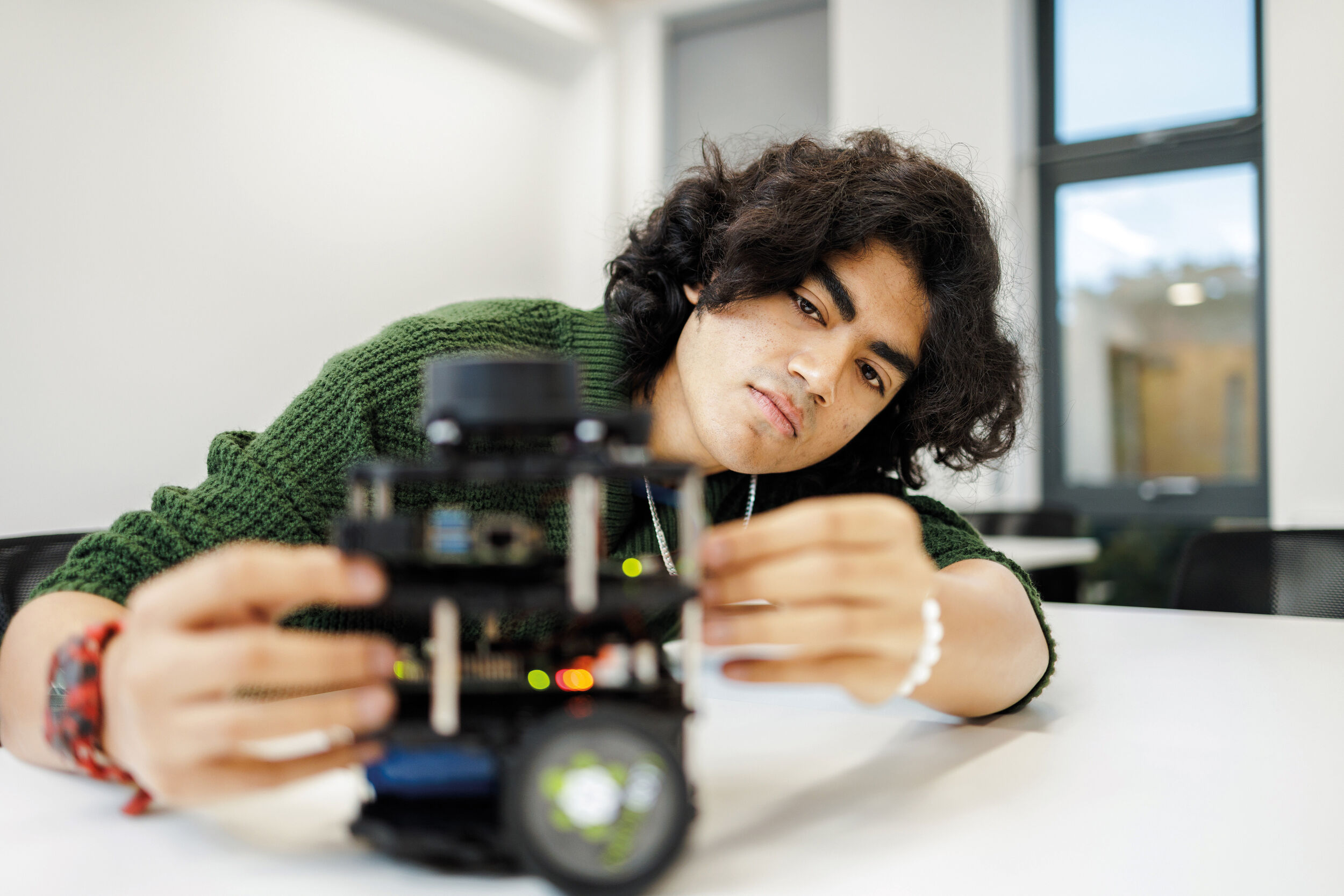 A University of Kent student looks at a robot.