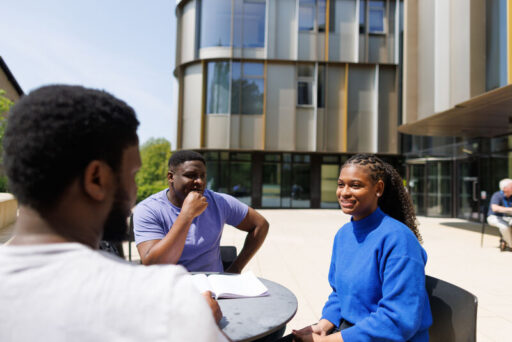 Three University of Kent students sitting outside chatting.