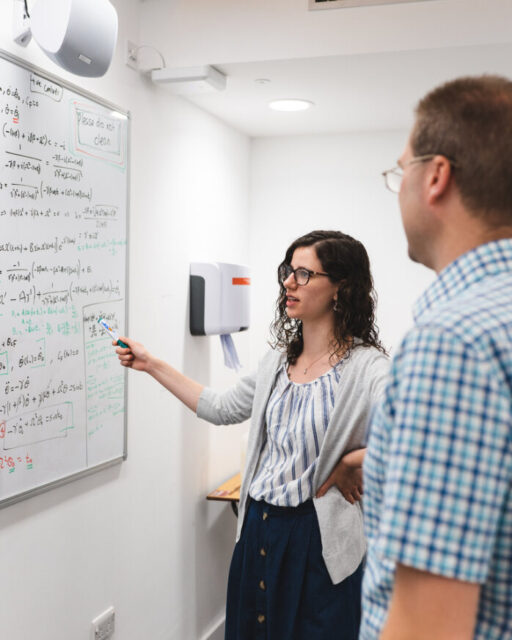 A Kent actuarial Science student studying with an academic at a white board.