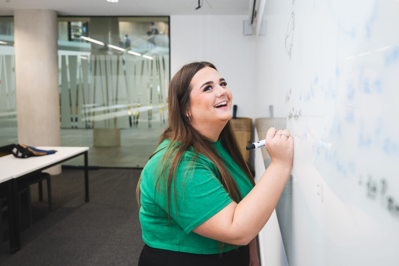 A Kent student at a white board.