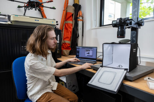 A student prepares photographs of a recent find for publication in the lab.